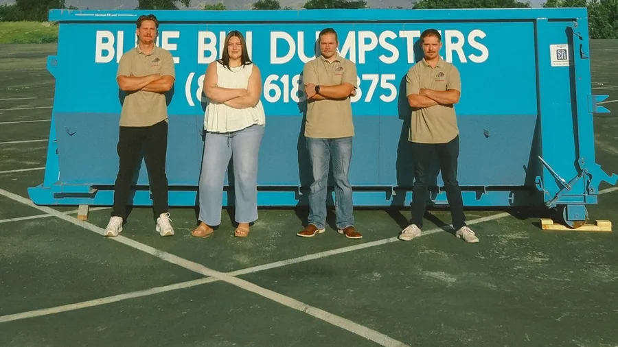 The Blue Bin team standing in front of one of their dumpsters